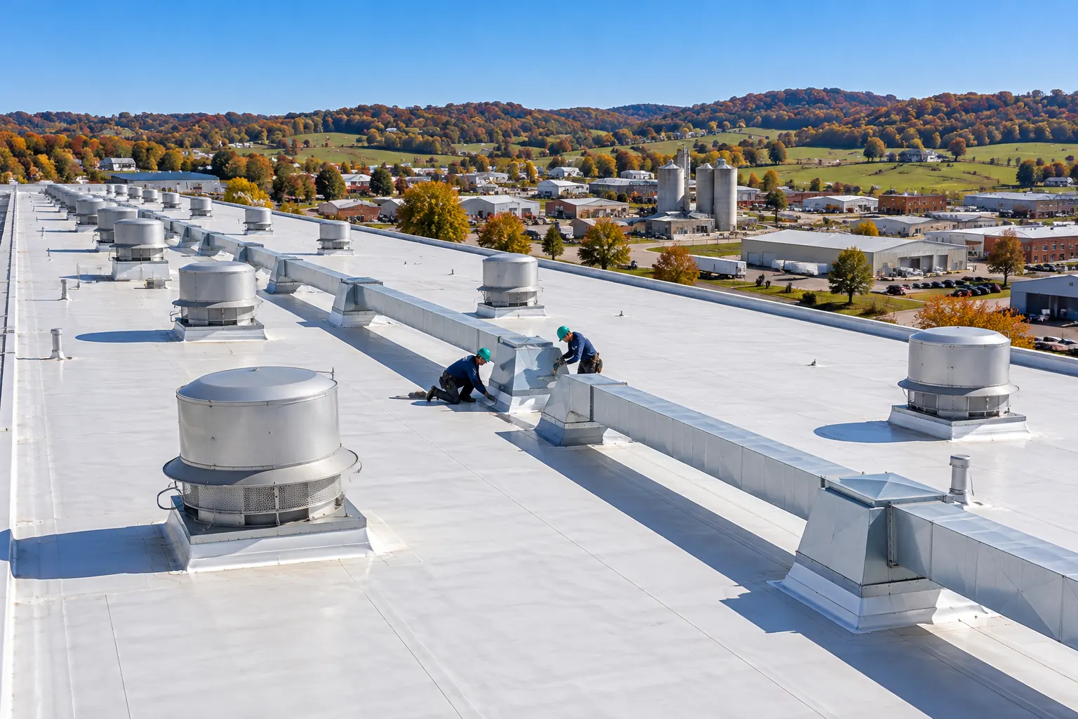 Aerial view of a large industrial roof with a crew at work